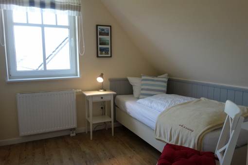 Ein Schlafzimmer im OG mit Einzelbett, auch hier großer Kleiderschrank und TV - Gerät. (nicht im Bild)