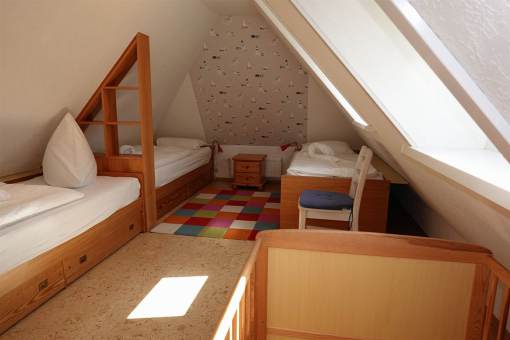 Das Kinderschlafzimmer mit 3 Betten, zus. ein Babybett aus Holz