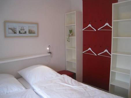 Weisse Regale, rote Paneelwand - farbenfrohes Schlafzimmer fr die Kinder.