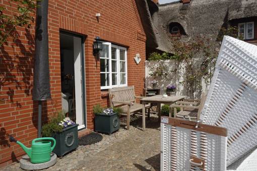 Die Terrasse mit Holzmbeln und Strandkorb