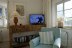 'TV Gerät im Wohnzimmer, im Vordergrund der Lesessel'